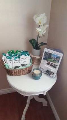 a white table topped with a basket filled with baby's breath notes and a candle