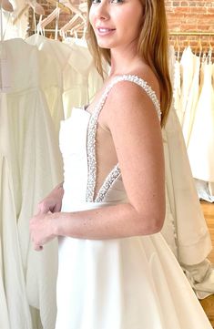 a woman standing in front of some dresses