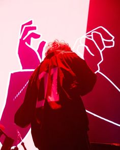 a man standing in front of a red and white wall