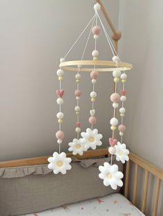 a crib mobile with flowers hanging from it