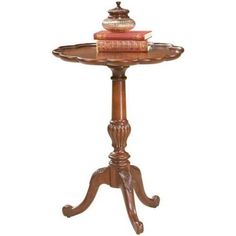 a wooden table with books on it and a candle holder sitting on top of it