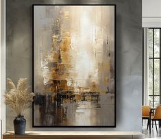 an abstract painting hangs on the wall next to a table with chairs and a vase