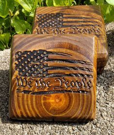 two wooden blocks with the words we are proud and an american flag painted on them