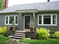 a gray house with white windows and steps leading up to the front door