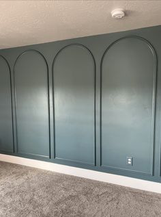 an empty room with blue painted walls and carpet