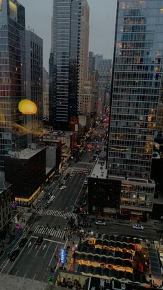 a city street filled with lots of traffic next to tall buildings and skyscrapers at dusk