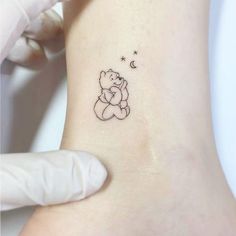 a small winnie the pooh tattoo on the ankle