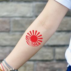 a woman's arm with a red and white tattoo on her left arm that reads stay strong