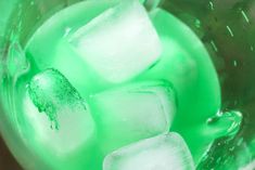 ice cubes in a glass filled with green liquid