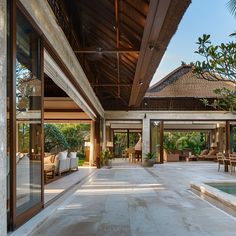 an outdoor living area with chairs and tables next to a pool in the middle of it