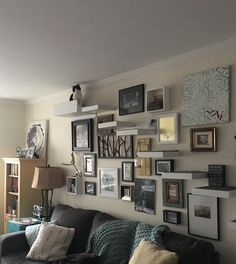 a living room filled with furniture and lots of pictures on the wall above it's couch