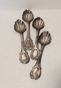 four silver spoons sitting next to each other on a table