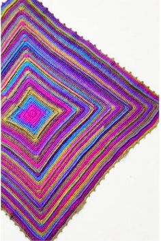 a multicolored crocheted blanket on a white surface