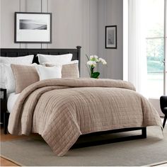 a bed in a bedroom with a brown comforter and white pillows