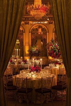 an elaborate dining room with chandeliers and tables set for dinner in the center