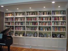 a piano is sitting in front of a bookshelf