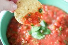 a tortilla chip being dipped with salsa