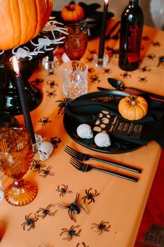 the table is decorated for halloween with black and orange decorations