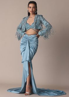 Introducing our beautiful indo western embroidered tasseled jacket and skirt. The intricately embroidered jacket adorned with delicate zardozi and beaded tassels provides a hint of class to any ensemble. Paired with a sky blue draped skirt this set exudes effortless appeal and beauty. Elevated with an embellished blouse this set is perfect for daylight soirees and nighttime gatherings. Dry clean only if required. Slight variation in color is possible due to digital photography. Fish Cut, Tassel Jacket, Fringe Clothing, Fusion Wear, Blue Drapes, Traditional Indian Outfits, Draped Skirt, Embellished Blouse, Blue Fish