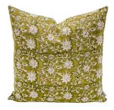 a green pillow with white flowers and leaves on the front, sitting on a white background