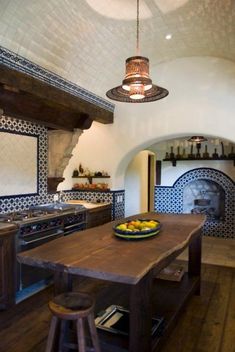 a large wooden table sitting inside of a kitchen next to a stove top oven and sink