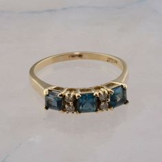 "14K Yellow Gold 1ct Blue Topaz and Diamond Ring, alternating blue topaz and diamonds, 3 princess cut 5mm blue topaz, 4 round diamond side stones, prong set, .8 inch across, open work to sides, marked \"JED\", Ring size 8.25, 2.8 grams SKU # BB319R22 Most rings are sizable for a small fee. If the ring you are considering is the incorrect size contact us for a quote. This listing contains photographs of the actual item you will receive. Our items are in excellent condition with little or no signs Vintage Blue Topaz Ring In 14k Gold, Elegant Multi-stone Topaz Ring In 14k Gold, 14k Gold Multi-stone Topaz Ring Fine Jewelry, 14k Gold Sapphire-color Topaz Ring, Blue Topaz Multi-stone Ring In 14k Gold, Claddagh Rings, Blue Band, Fine Jewelry Designers, Size 10 Rings