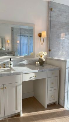 a white bathroom with two sinks and a large mirror on the wall next to it