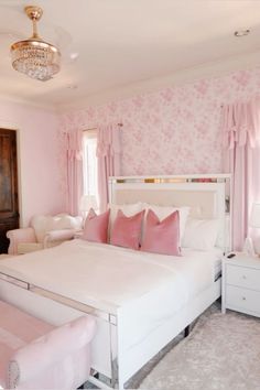 a bedroom with pink walls and white furniture