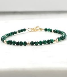 "Malachite gemstone bracelet, gold filled, green gemstone jewelry, green beaded jewelry, malachite gemstone jewelry, gift for her This dainty bracelet features deep green Malachite gemstones accented with metal beads. This is the perfect bracelet for layering with your other pieces.  -MATERIALS- -Gemstone: Genuine Malachite faceted beads.  Stones are approx 3mm.  -Metal beads: Approx 2.5mm available in your choice of gold filled, or sterling silver.  -MEASUREMENTS- Bracelet is 6.5\" + 1.5 extender\" adjustable to 8\". If you would prefer to have the bracelet fit a specific wrist size rather than having an extender chain, please leave a note in the message to seller notes at checkout indicating the desired size. -PRODUCTION TIMES- All items are made to order and will ship within 2-3 busines Interlocking Circle Necklace, Minimal Bracelet, Intention Bracelets, Green Beaded Bracelets, Malachite Bracelet, Malachite Jewelry, Green Malachite, Dainty Bracelet, Beaded Bracelets Diy