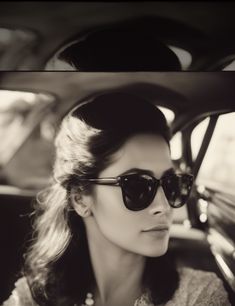 a woman wearing sunglasses sitting in a car