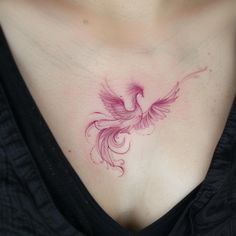 a woman's chest with a pink bird tattoo on her left shoulder and breast