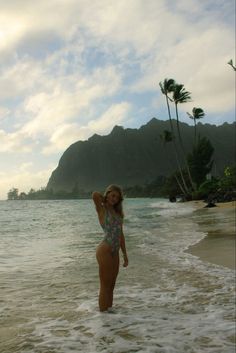 a woman is standing in the water at the beach