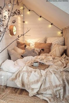 an instagram photo of a bed in a loft with lights strung from the ceiling