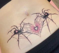 a spider tattoo on the side of a woman's stomach, with two black and red webs