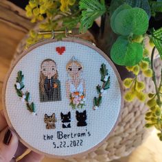 the bride and groom are depicted in this hand embroidered wedding ornament, which is surrounded by greenery