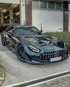 a black mercedes sports car parked in front of a building