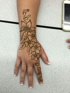 a woman's hand with henna tattoos on it