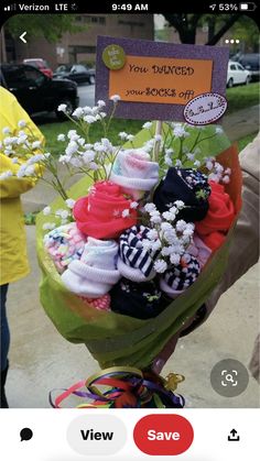 a bouquet of socks and baby's breath flowers is on display in front of a sign