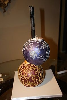 two decorative vases sitting on top of a white plate with a pen sticking out of it