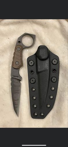 two knives are laying next to each other on a white surface with black trimmings