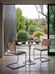 two chairs sitting at a round table in front of a sliding glass door