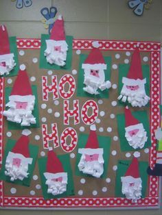 some paper santa clauss and other decorations on a bulletin board