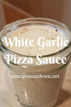 white garlic pizza sauce in a glass jar with the words, white garlic pizza sauce