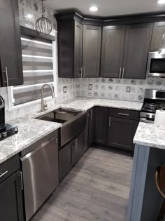 a kitchen with gray cabinets and stainless steel appliances