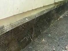 there is a wire fence that has been placed on the side of a building with water coming out of it