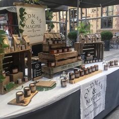 an outdoor market with lots of wooden boxes and jars on it's display table