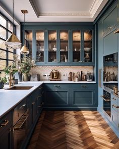 a kitchen with blue cabinets and wooden floors