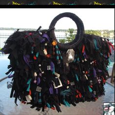 a handbag made out of black fabric and colorful beads