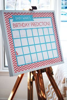 a baby's birth announcement board on a tripod in front of a window