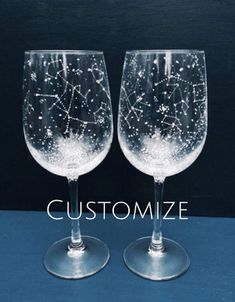 two wine glasses with stars on them sitting side by side in front of a blue background